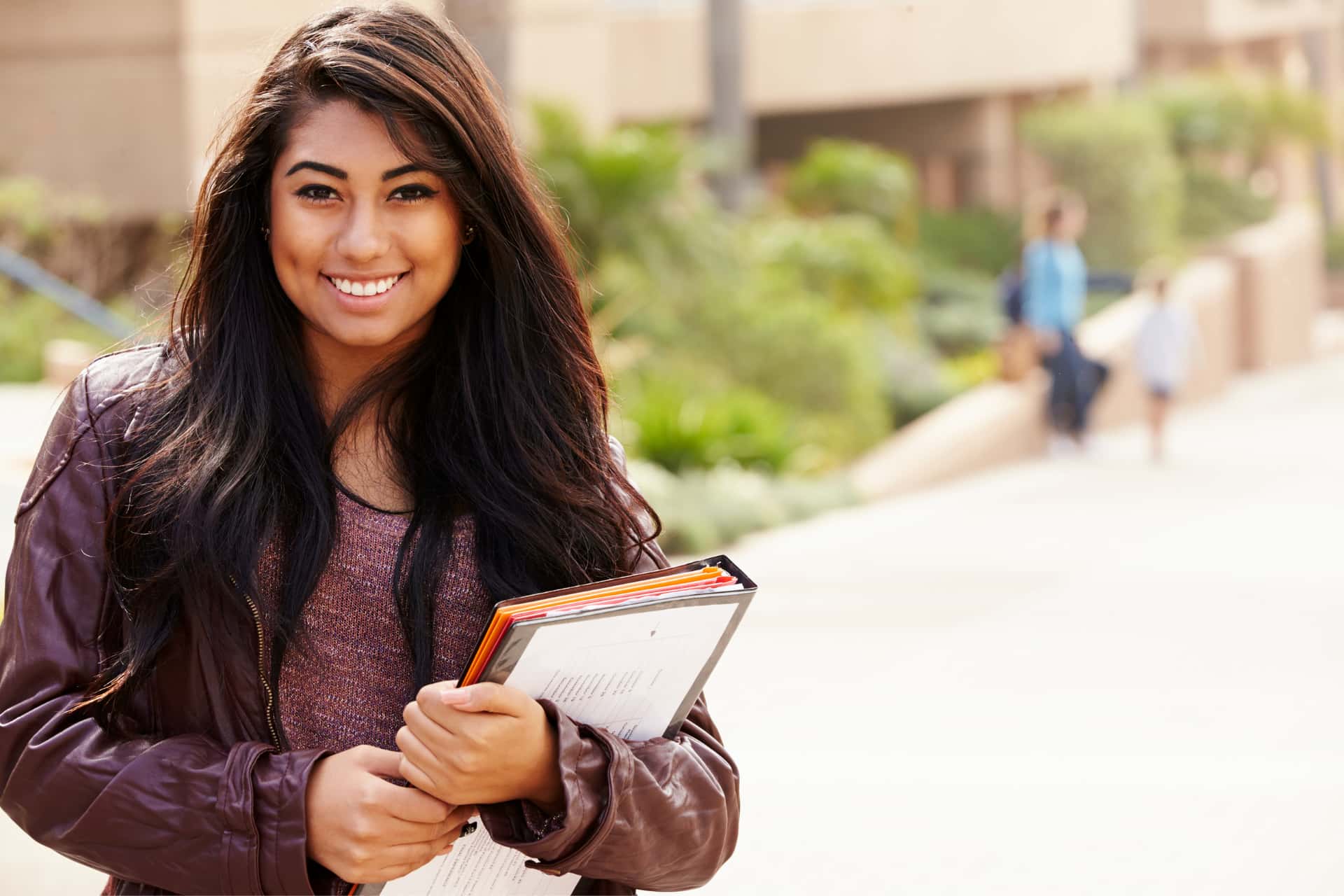 Smiling young professional holding notebook. 