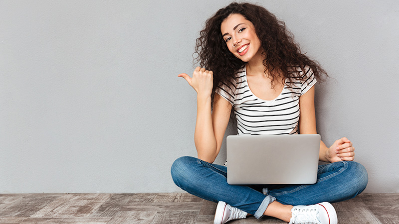 Woman sitting on floor with laptop computer